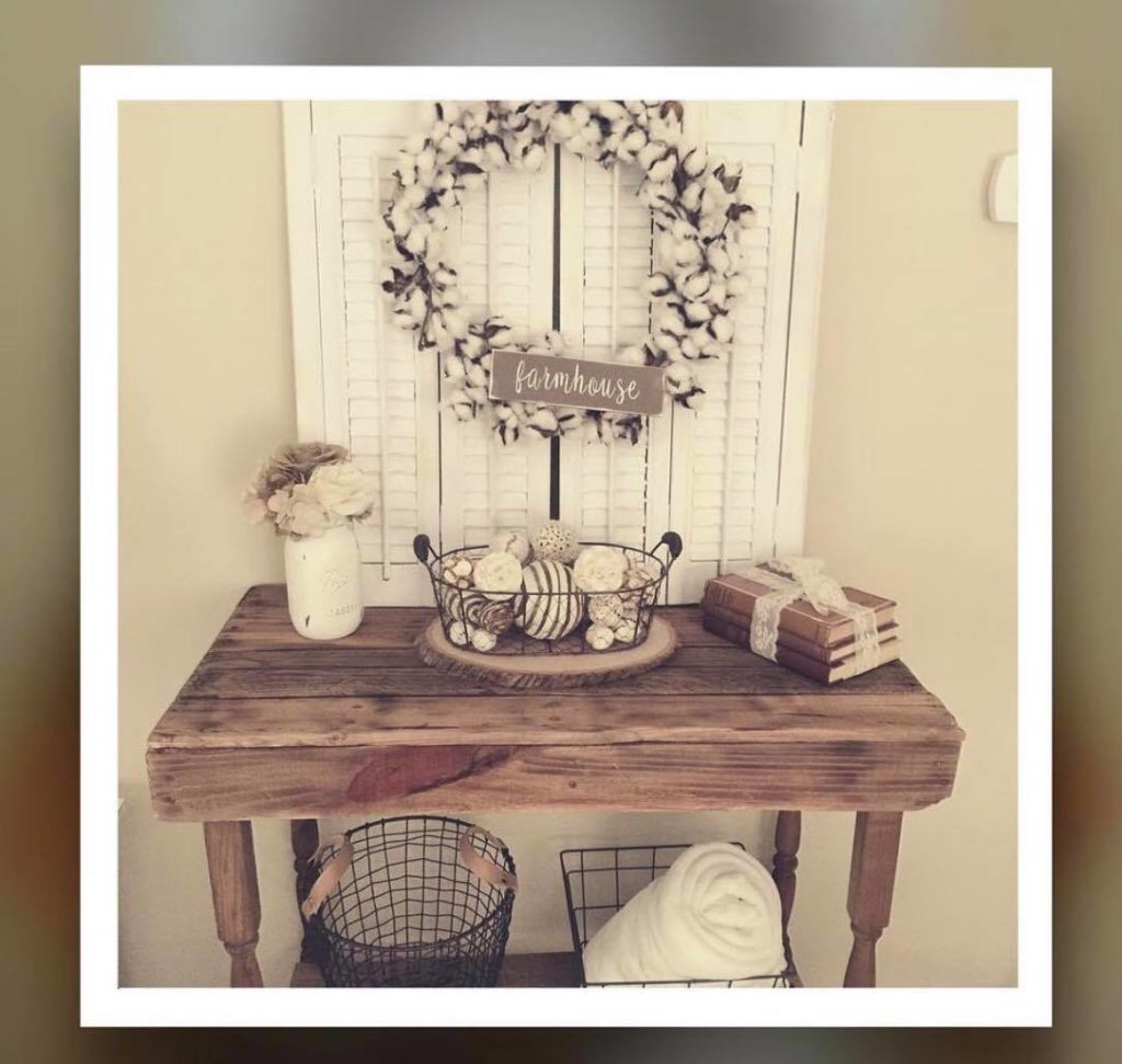 Pallet wood table with shutters on top with wreath in the middle decorated with farmhouse decor. 