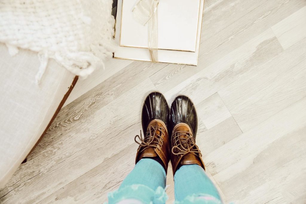 Shot of wood plank floors with presents on floor and girl wearing boots