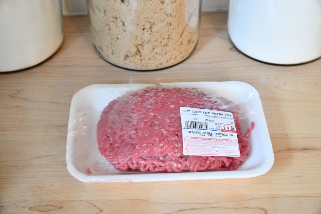 Hamburger meat in package sitting on kitchen counter