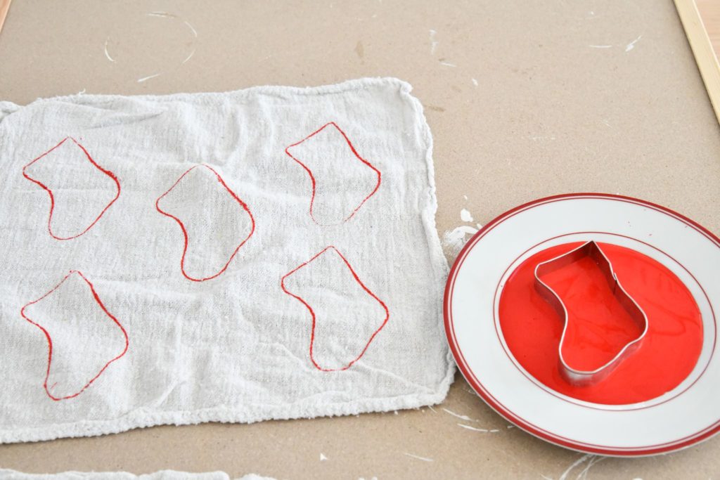 Red paint stocking cookie cutter stamped on towel