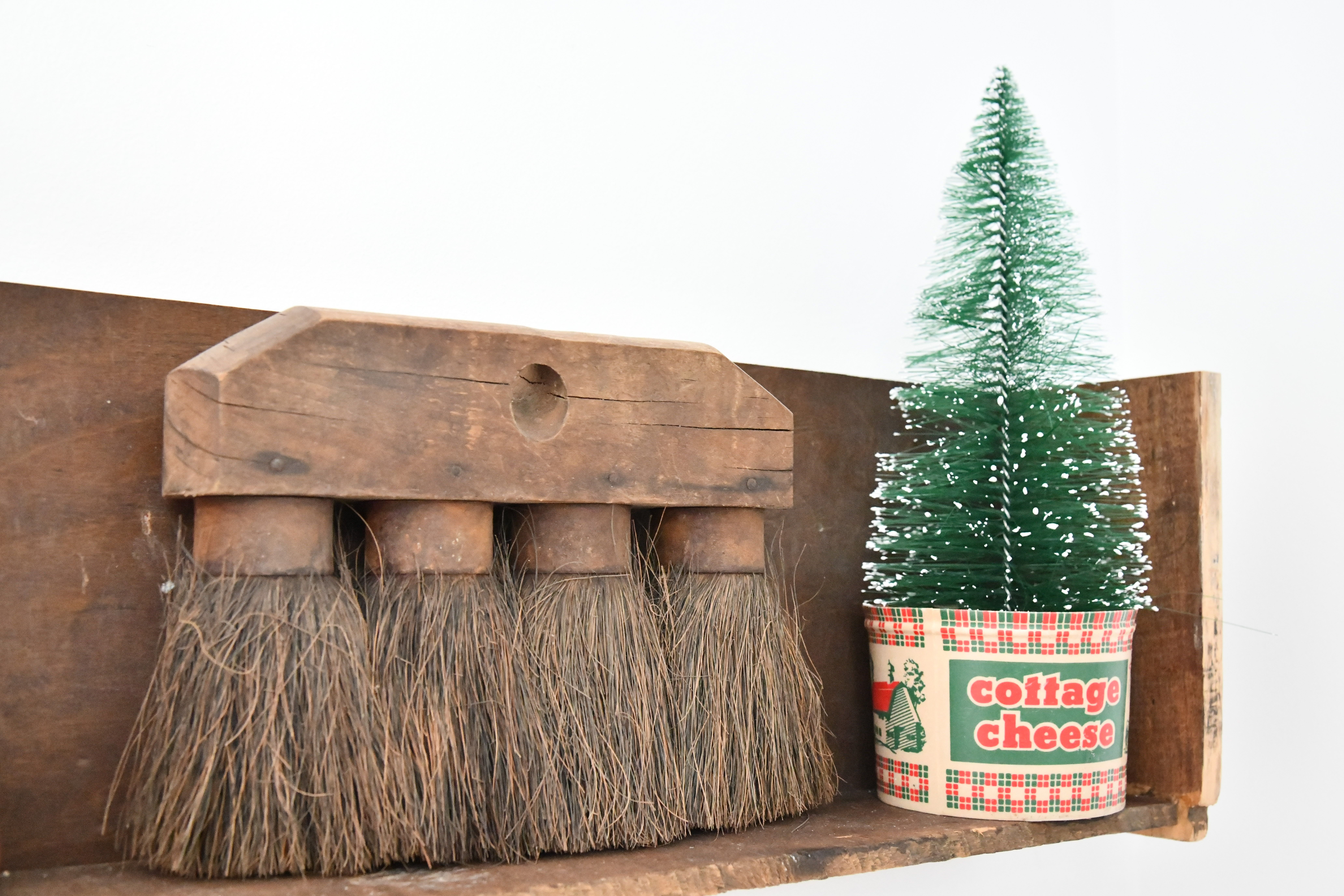 Vintage Christmas Tree Stands Mini Tree in vintage cottage cheese container with vintage brush on shelf 