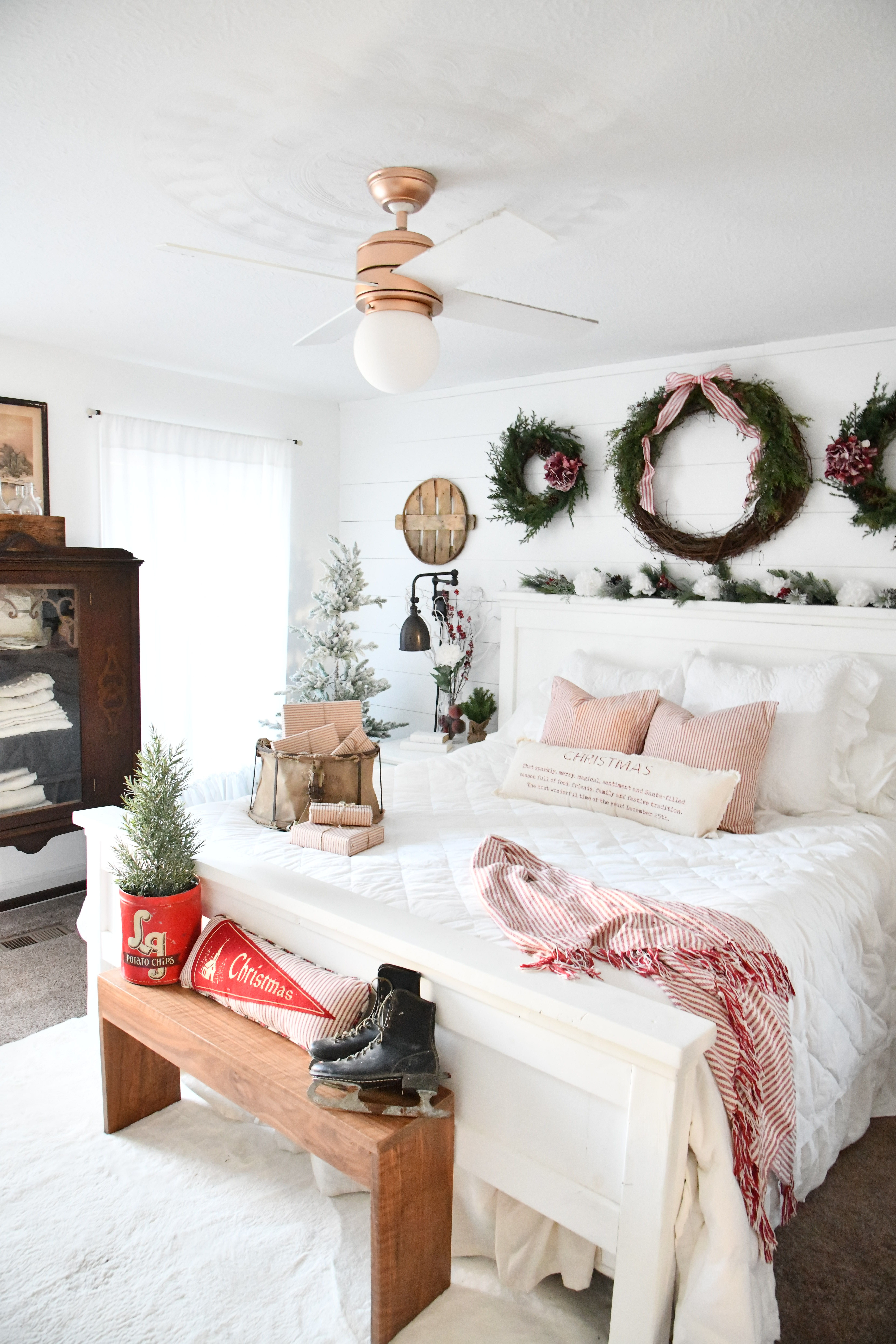 farmhouse style Christmas bedroom with white and red decor and flocked tree
