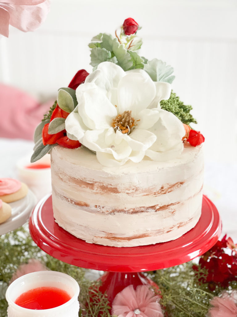 faux valentines day cake on red cake stand with punch