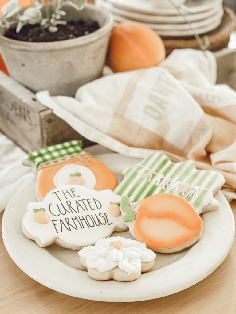 If You Love Peaches You Will Love this Tablescape pertty peach themed cookies and orange tea towel in crate
