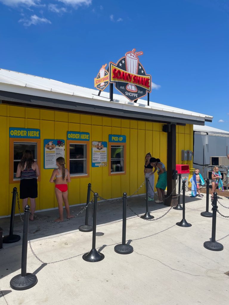 soaky Shake shop yellow building people in swimsuits getting ice cream