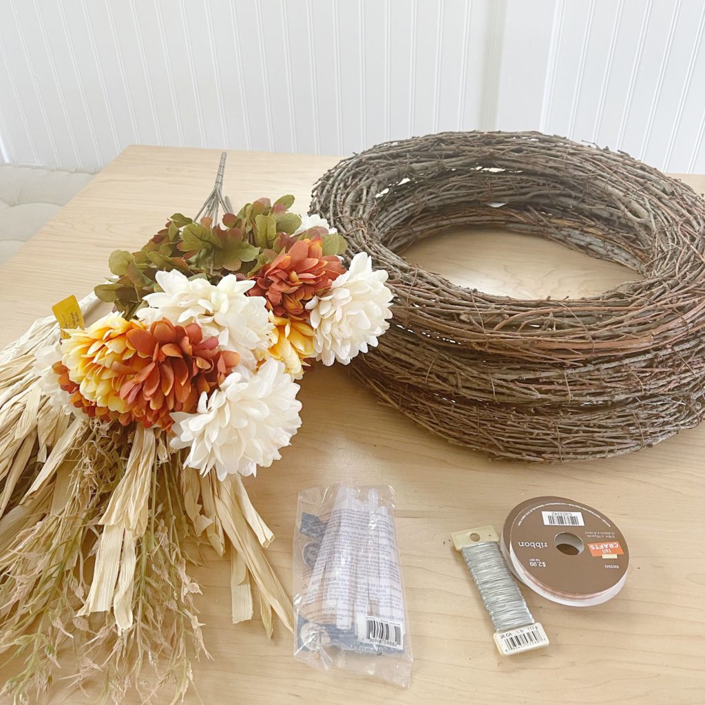 3 grapevine wreaths fall florals wheat bush glue sticks floral wire and ribbon sitting on table