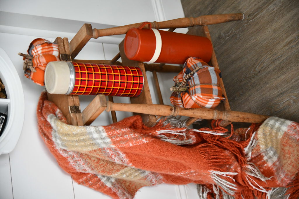 How To Beautifully Decorate Your Entryway For Fall pumpkins and thermos and plaid blanket