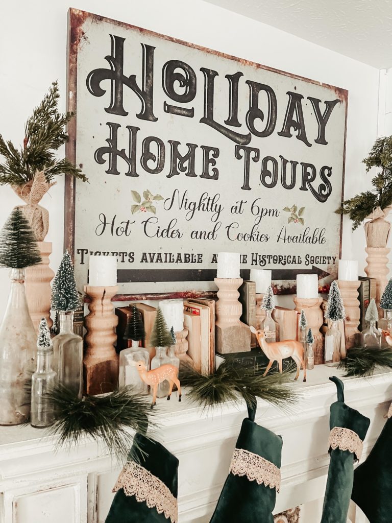 holiday home tour chippy vintage rustic looking sign on mantle with wood candlesticks and white candles