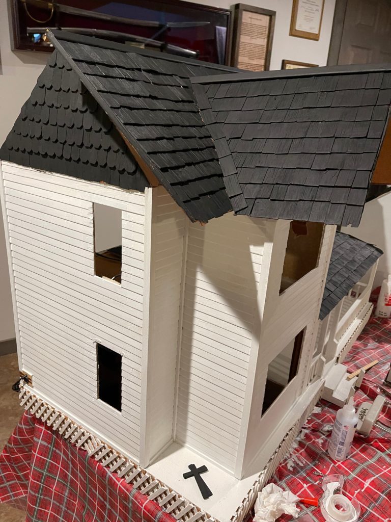 left side view of dollhouse painted white with black roof