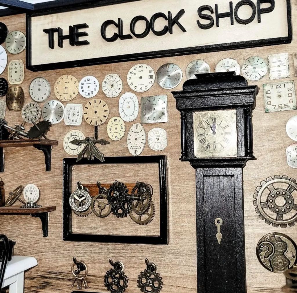 Miniature dollhouse clock shop back wall with clock shop sign and clock faces on wall