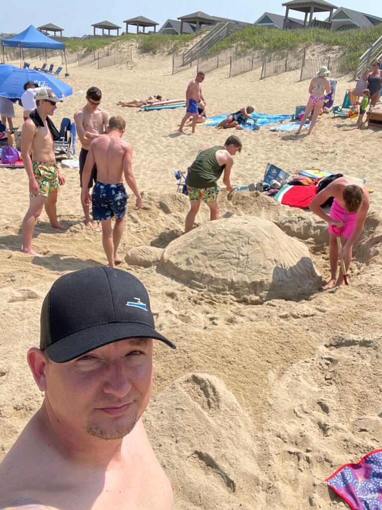 photo of family building a tutrle sandcastel in the outer banks on beach