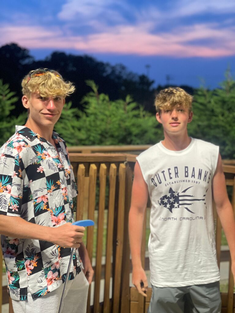 2 teen boys playing put put golf in the outer banks nc